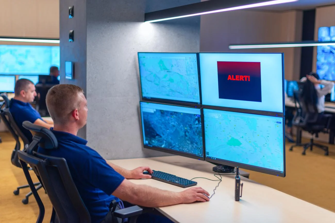 Operators watching a bank of monitors in a secure control room